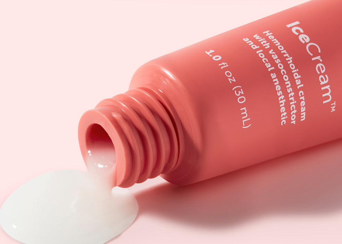 Pink tube of 'IceCream' cream with a small amount of cream spilling out on a light pink background.