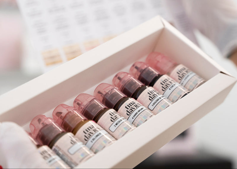 Set of small bottles with visible labels in a box, blurred background